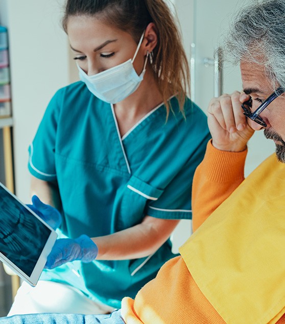 Patient and dental team member reviewing X-ray