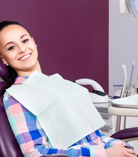 Woman sitting in dental chair and smiling