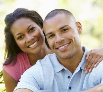 Man and woman smiling after periodontal therapy